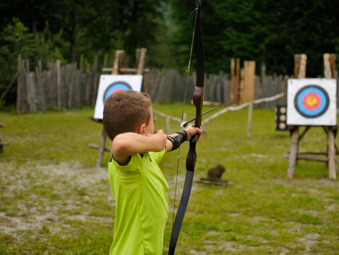 enfant visant une cible avec un tir à l'arc
