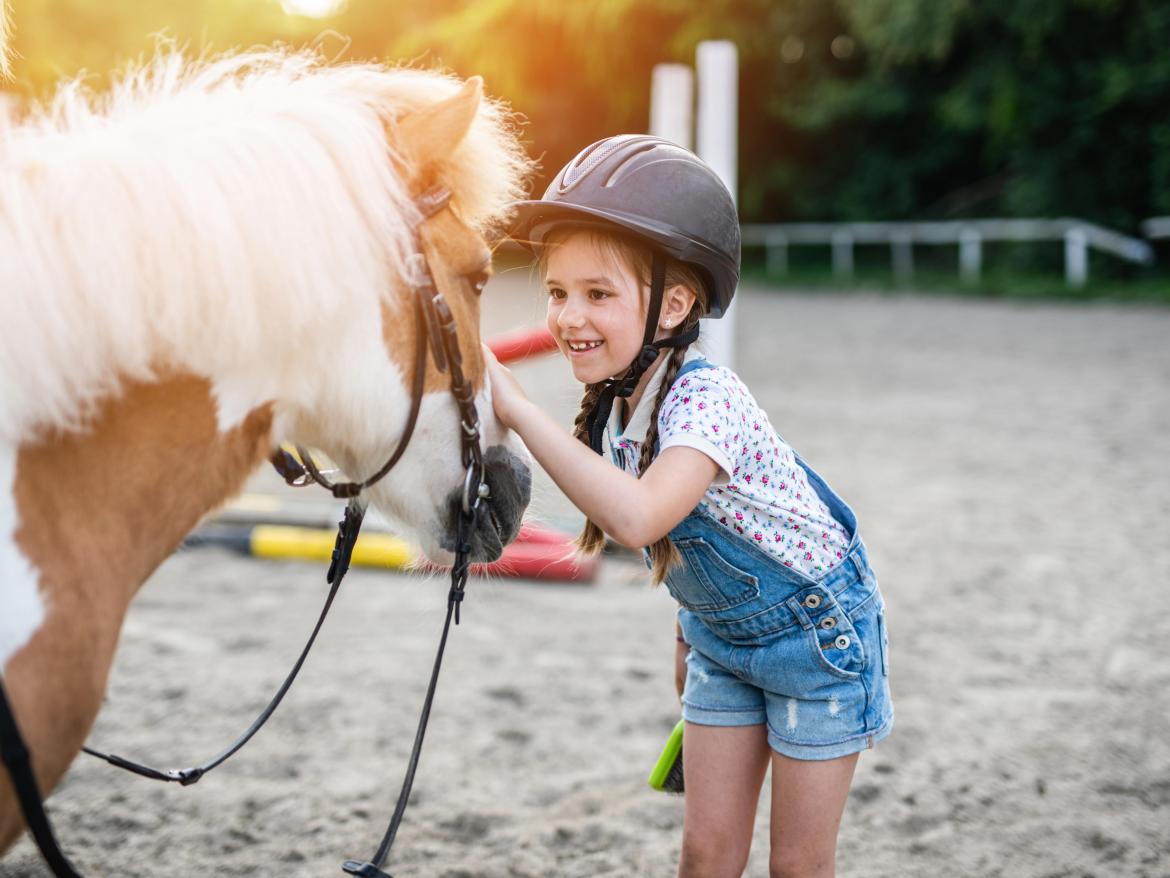 enfant faisant un calin à son poney