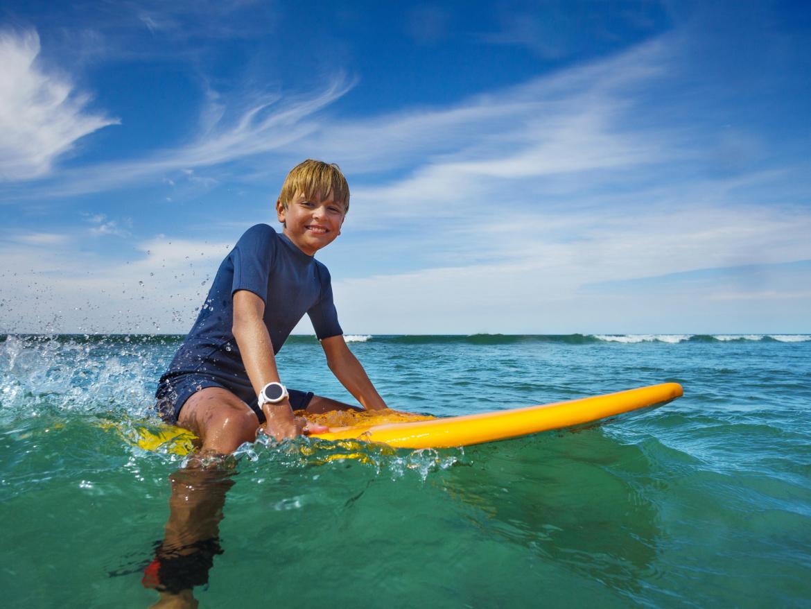 enfant sur un surf dans la mer