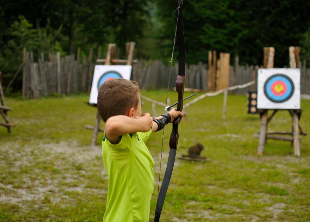 enfant visant une cible avec un tir à l'arc