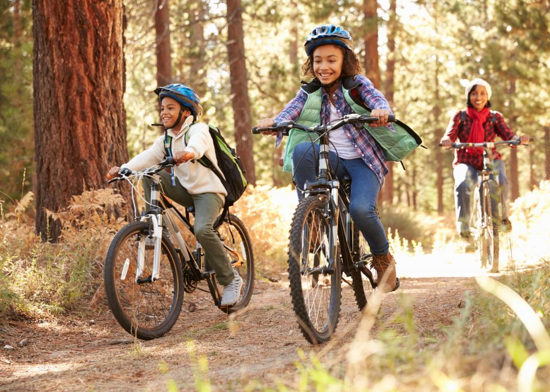 Trois enfant pédalant à vélo en forêt